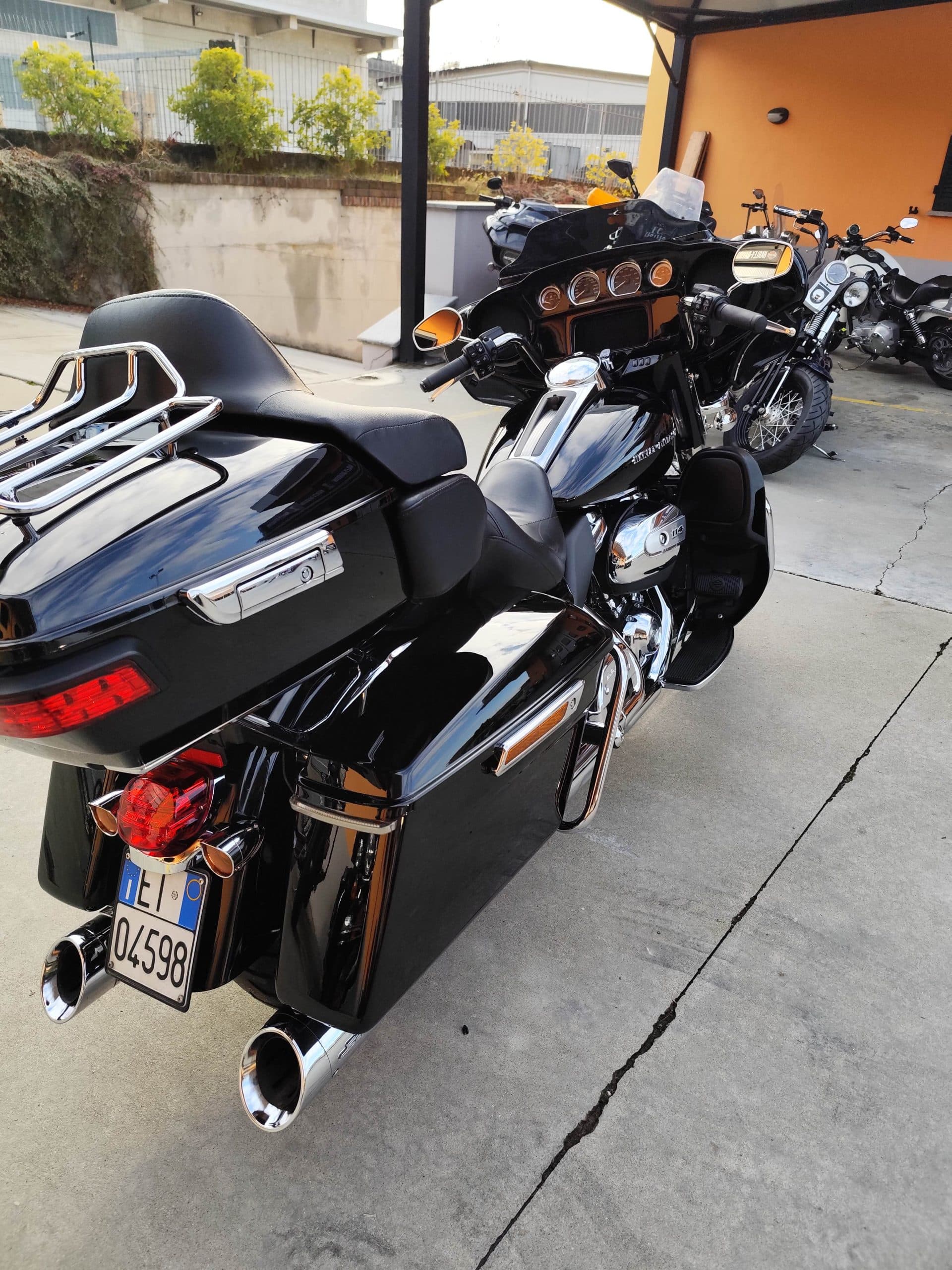 Harley-Davidson touring nera con motore 114, borse laterali e dettagli cromati, parcheggiata. Targa italiana visibile. Ideale per test ride.