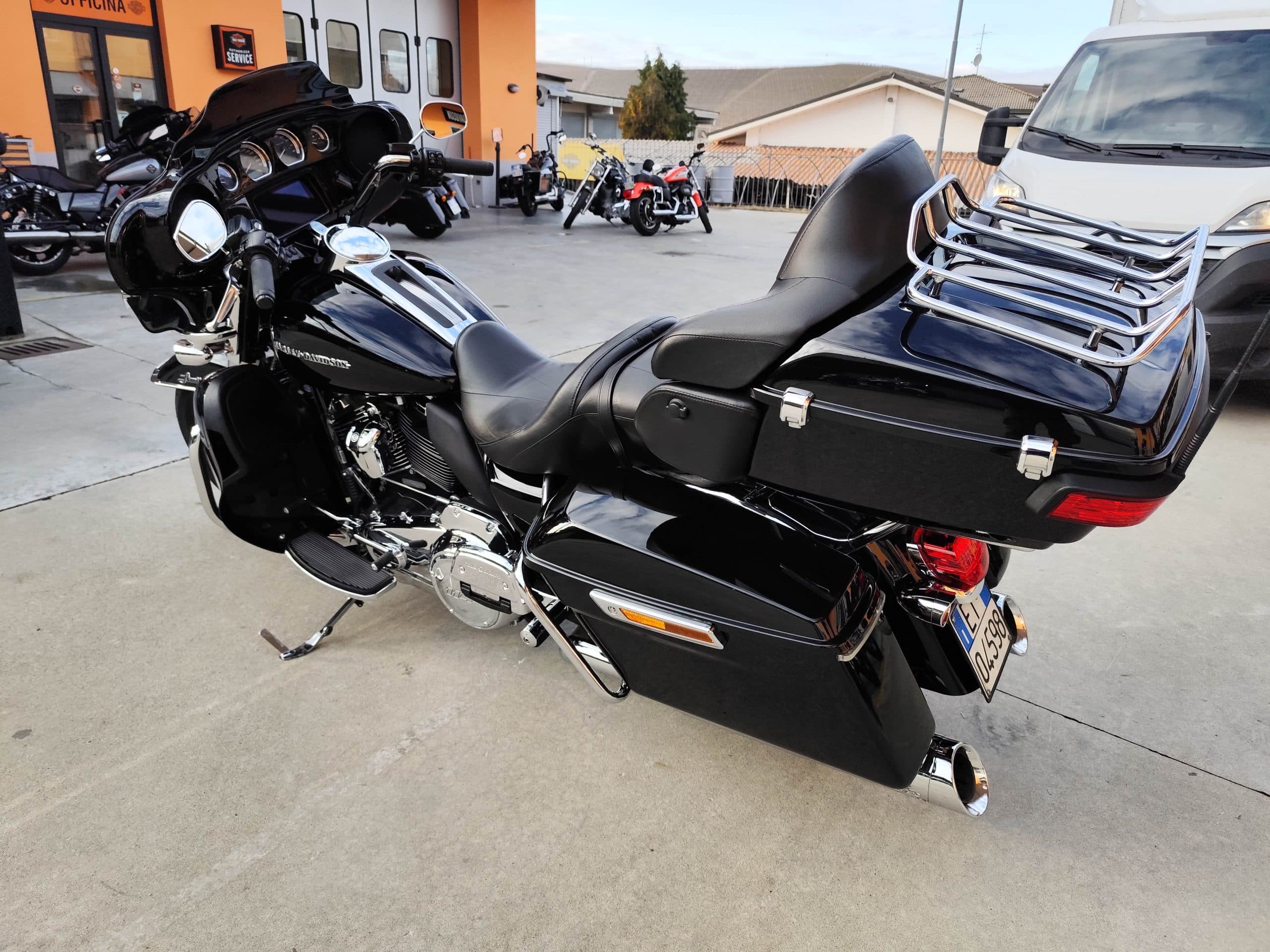 Harley-Davidson touring nera lucida con carenatura, borse laterali e top case, esposta presso concessionaria autorizzata per vendita o test ride.