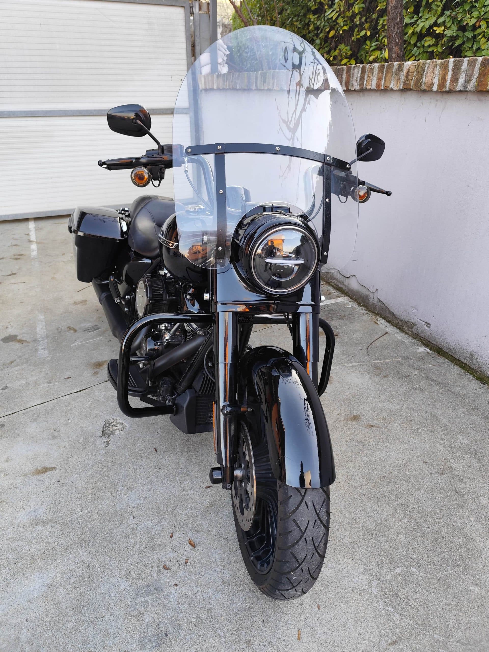 Harley-Davidson nera lucida, equipaggiata con ampio parabrezza, faro LED circolare e borse laterali rigide. Moto pronta per test ride.