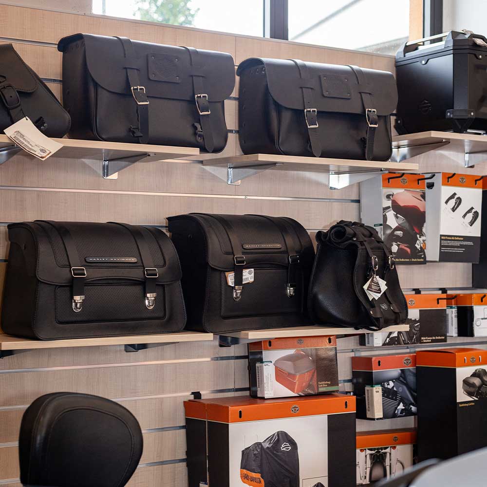 Esposizione di borse laterali, valigie e top case in pelle nera originali Harley-Davidson per moto, accessori disponibili in concessionaria.