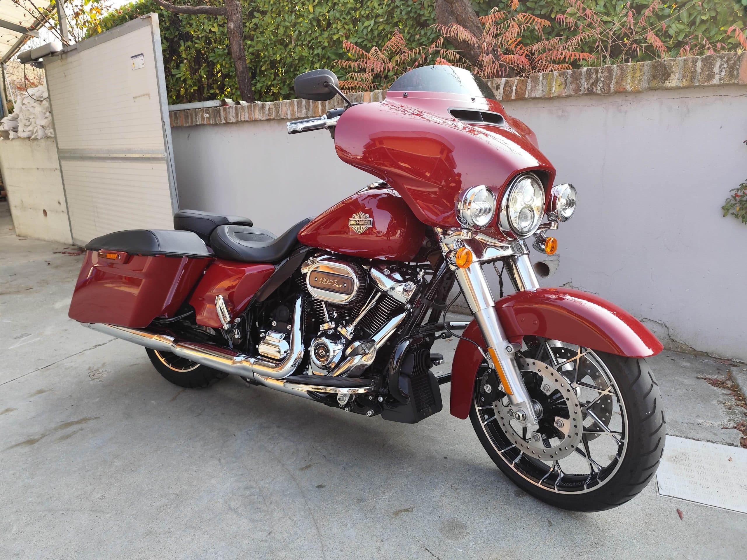 Harley-Davidson touring rossa con motore 114 ci, parcheggiata all'aperto. Dettagli cromati e carenatura lucida. Ideale per test ride.