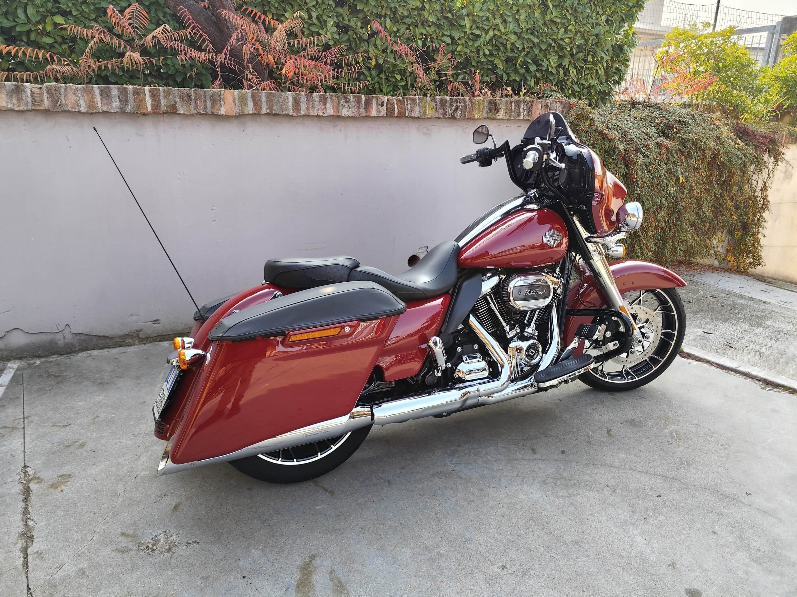 Harley-Davidson touring rossa, con motore Milwaukee-Eight 114ci e finiture cromate, parcheggiata su cemento. Ideale per test ride.
