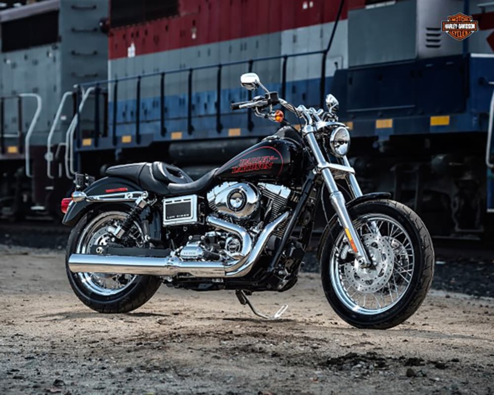 Harley-Davidson Low Rider FXDL nera, motore Twin Cam cromato, scarichi lucidi, ruote a raggi. Ideale per test ride e appassionati motori.