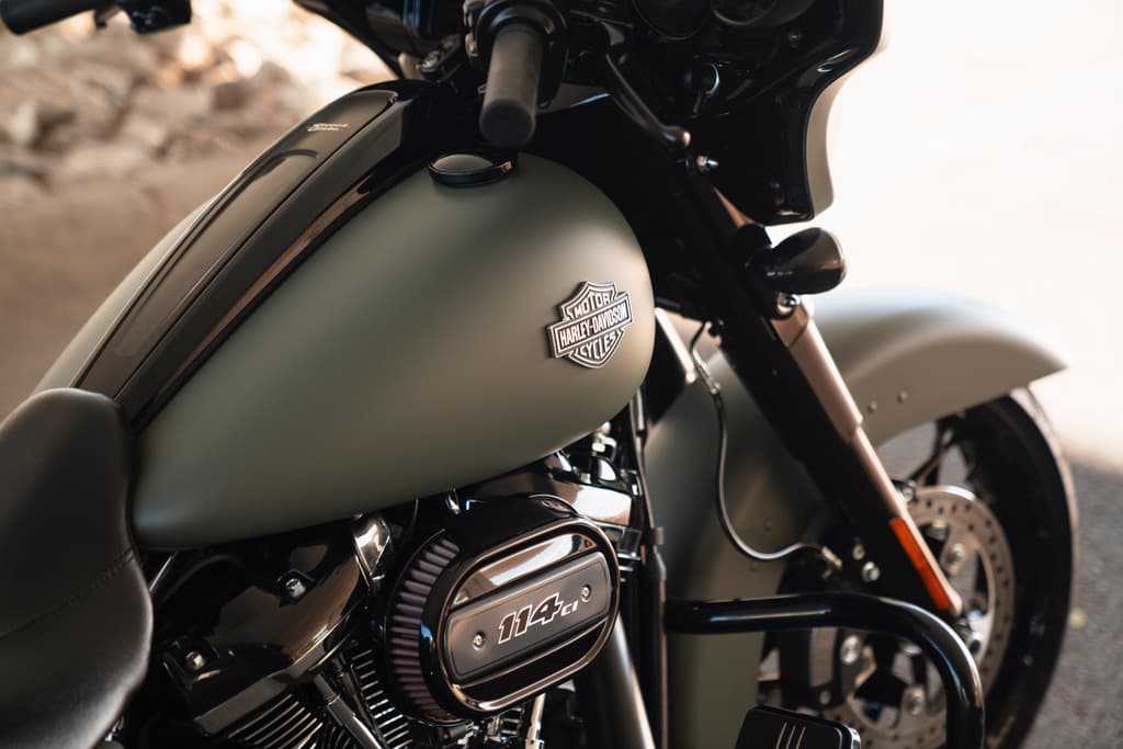 Moto Harley-Davidson con serbatoio verde opaco, logo e motore 114 cu. in. Dettagli di design e finiture cromate.