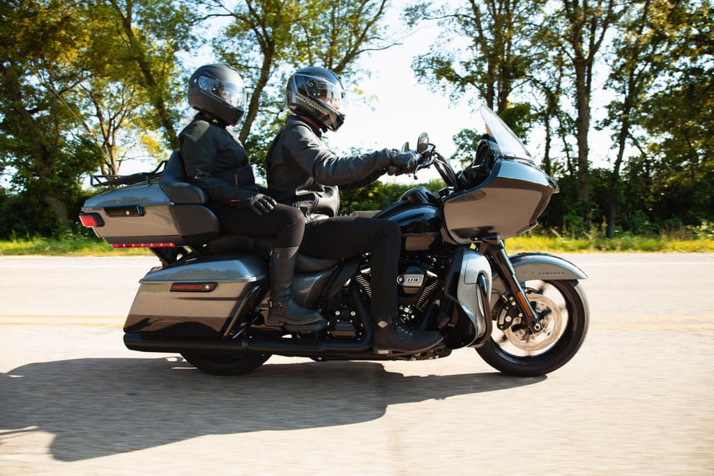 Coppia su moto Harley-Davidson touring con motore Milwaukee-Eight 114, abbigliamento tecnico, in movimento su strada. Ideale per test ride.