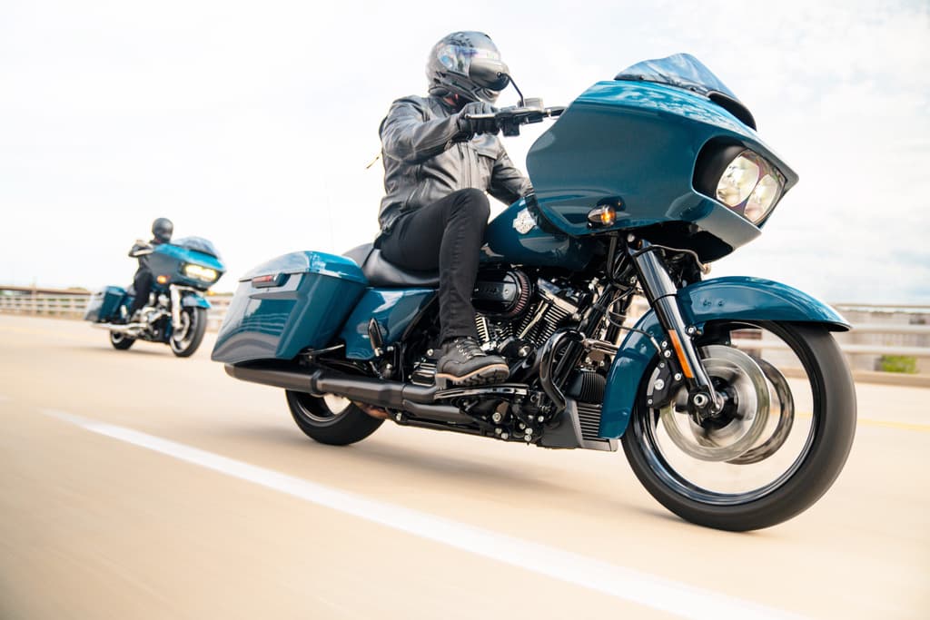 Harley-Davidson Road Glide color teal con pilota in abbigliamento tecnico, in movimento su strada. Motori e test ride in evidenza.