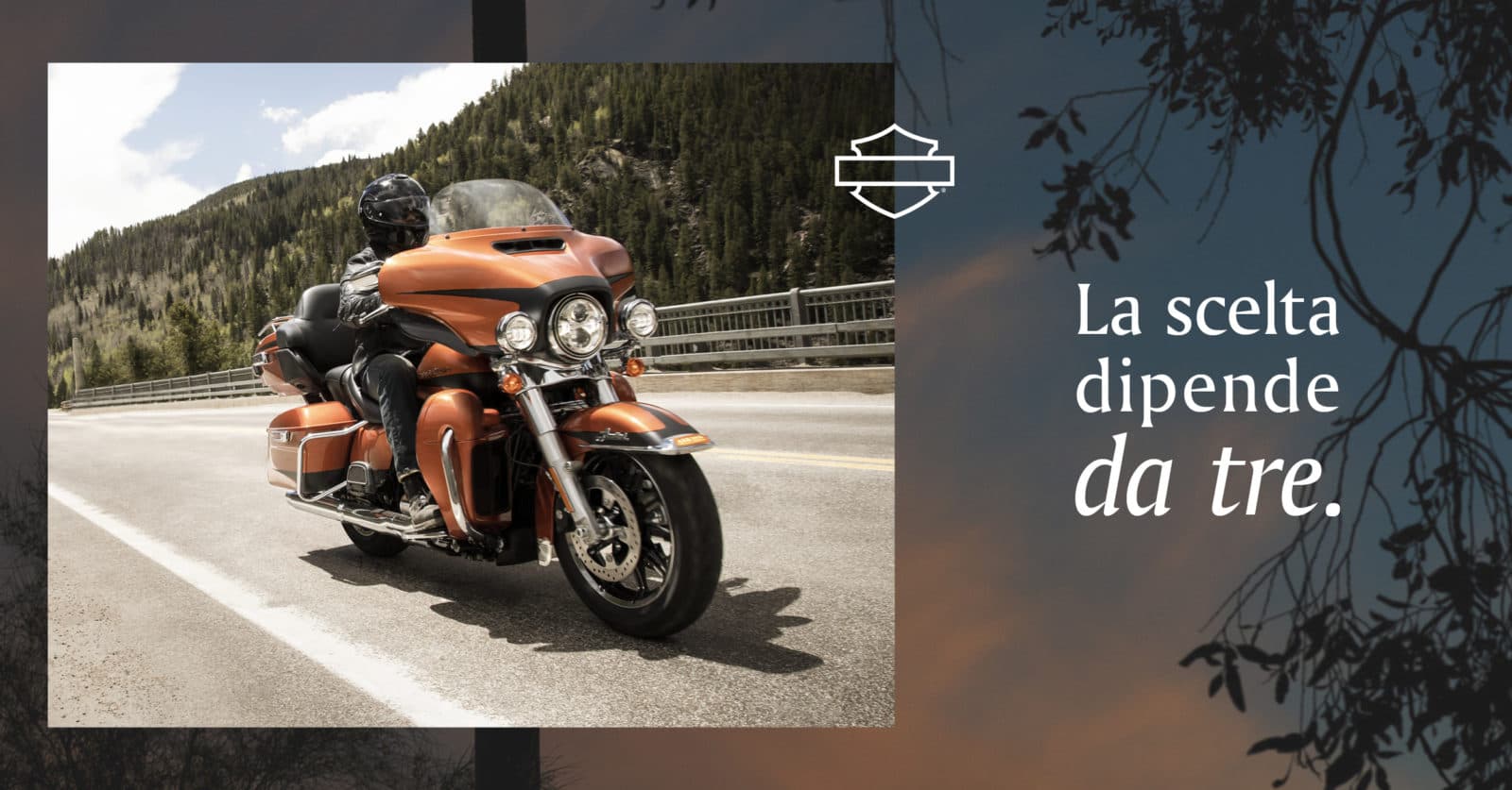 Harley-Davidson touring arancione con pilota su strada montana. Logo Harley-Davidson. Testo: La scelta dipende da tre.