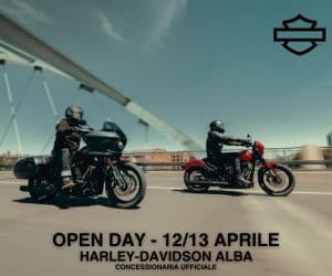 Due motociclisti su moto Harley-Davidson (touring nera e cruiser rossa) su un ponte. Promozione Open Day e test ride Harley-Davidson Alba 12/13 Aprile.