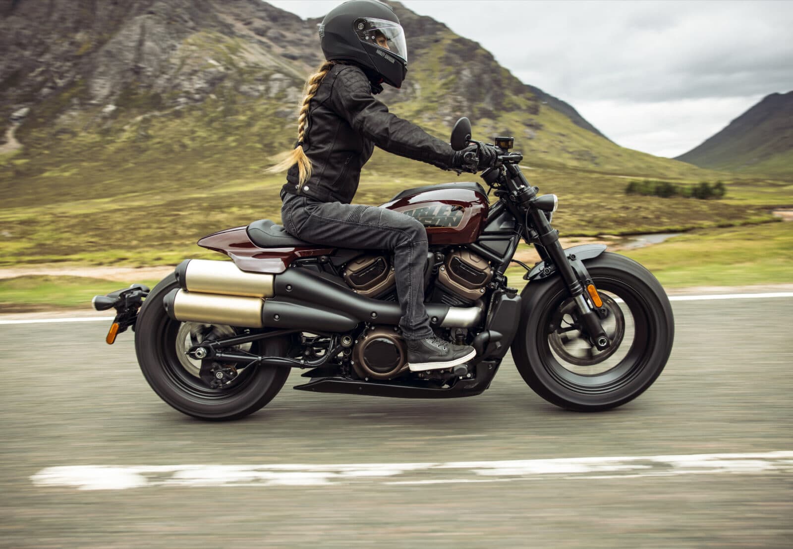 Motociclista con casco integrale e abbigliamento tecnico guida una Harley-Davidson Sportster S su strada panoramica, evidenziando il test ride.