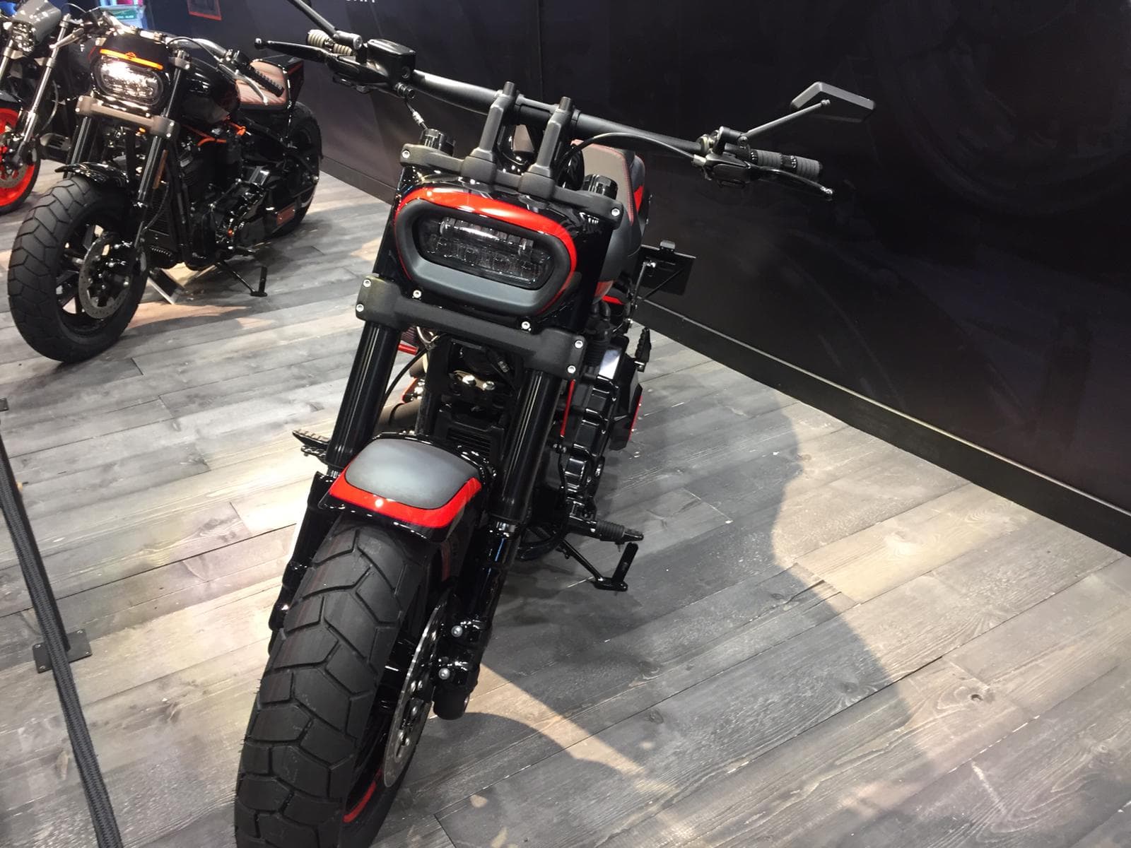 Harley-Davidson moderna, nera con dettagli rossi, esposta in showroom. Design aggressivo, pronta per un test ride e per gli appassionati di motori.