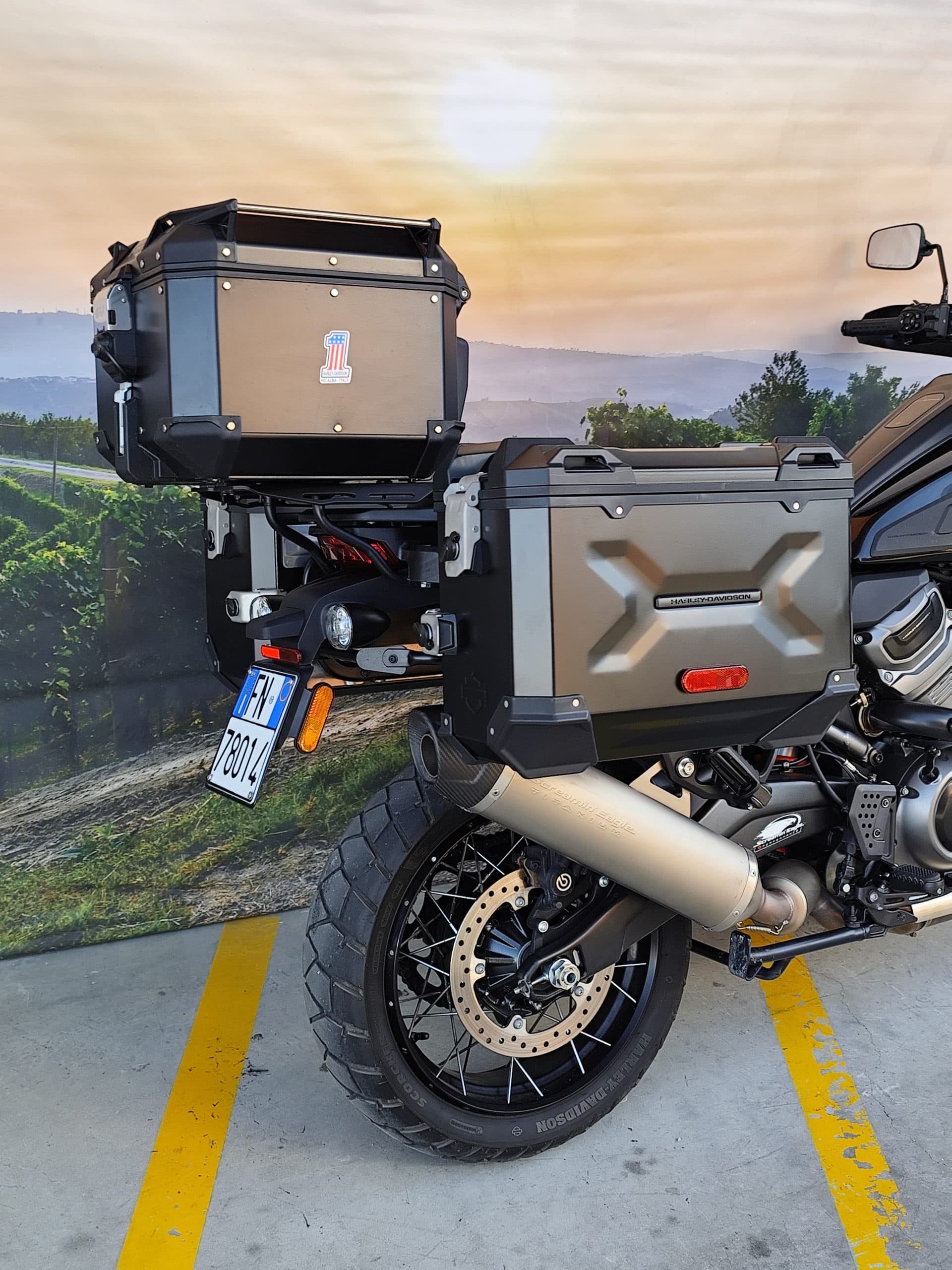 Moto Harley-Davidson adventure touring con valigie laterali e top case, scarico Screamin' Eagle Titanium, esposta presso HD Alba Italy.