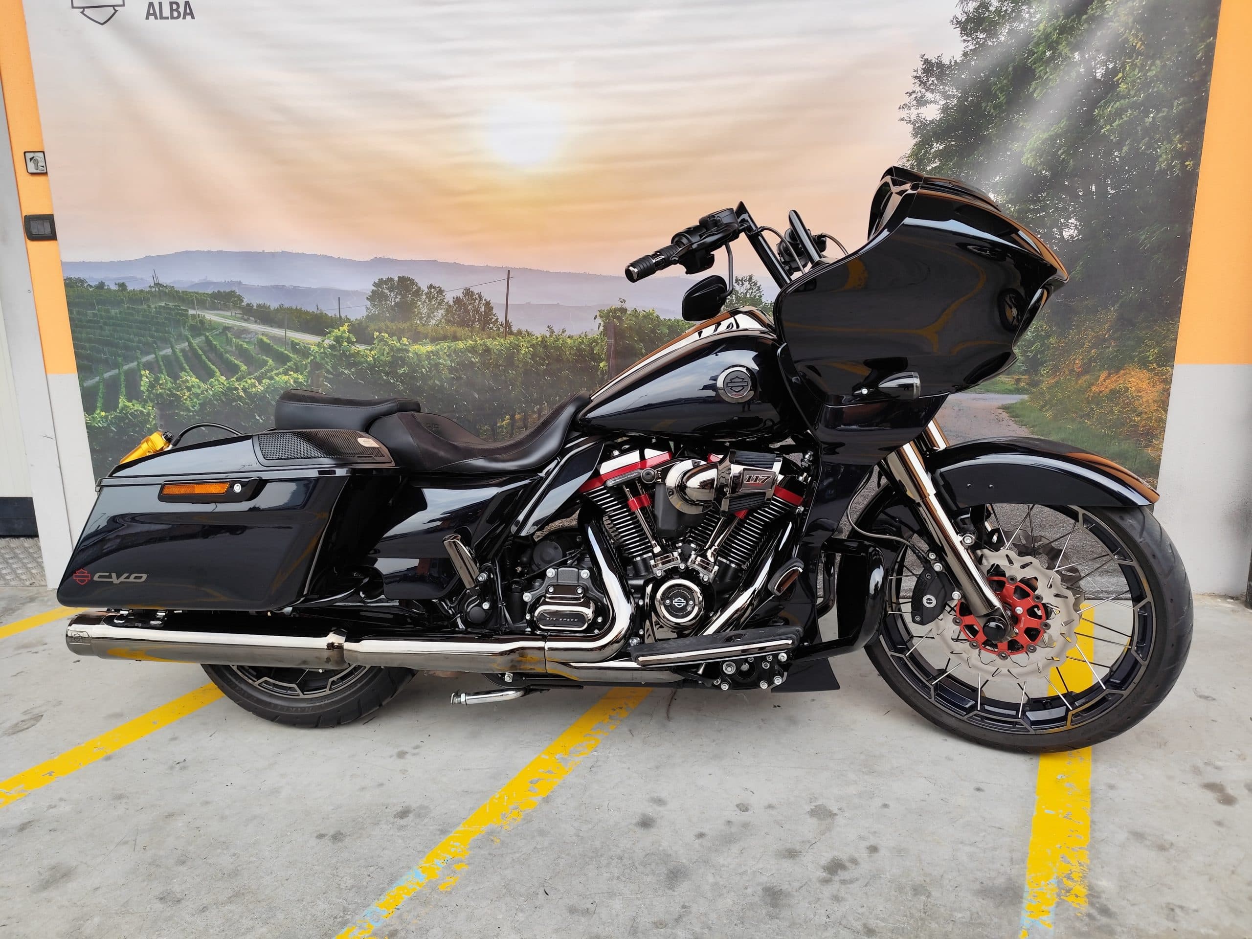Harley-Davidson CVO nera con motore 117, dettagli cromati e pinze freno rosse, esposta su sfondo paesaggistico di vigneti. Ideale per test ride.
