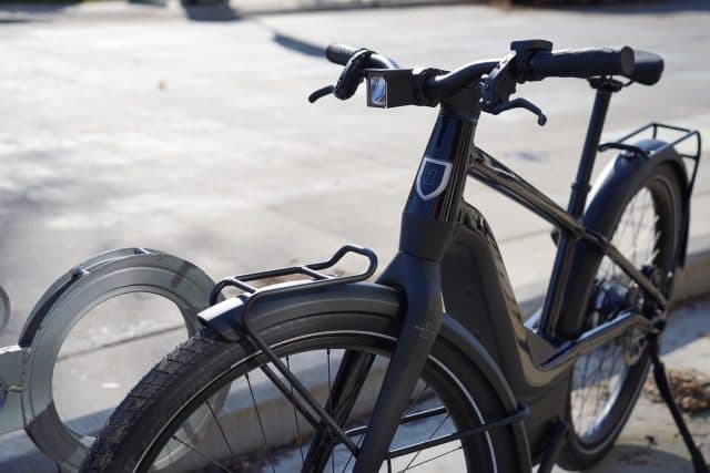 Bicicletta elettrica Serial 1, spin-off di Harley-Davidson, di colore nero, con parafanghi, portapacchi anteriore e logo distintivo.