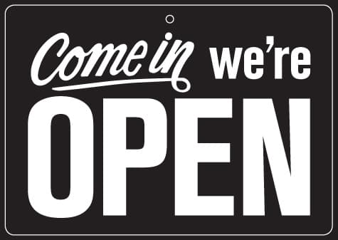 Cartello nero con scritta bianca 'Come in we're OPEN', invita i clienti a entrare nella concessionaria Harley-Davidson.