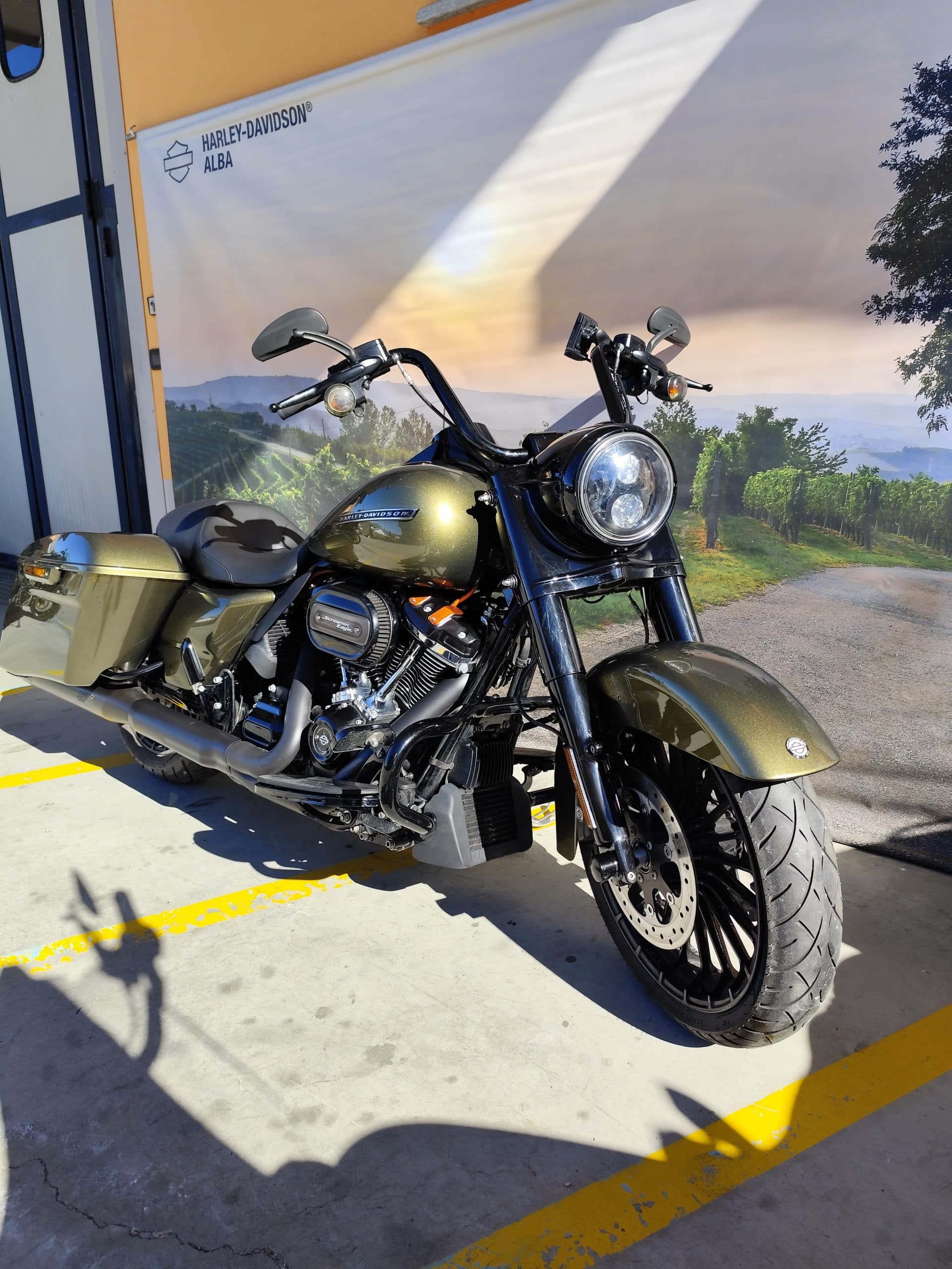 IMG_20260217_122031.jpg Moto Harley-Davidson touring verde metallizzato, con motore Screamin' Eagle, esposta presso la concessionaria Harley-Davidson Alba, su sfondo paesaggio delle Langhe.