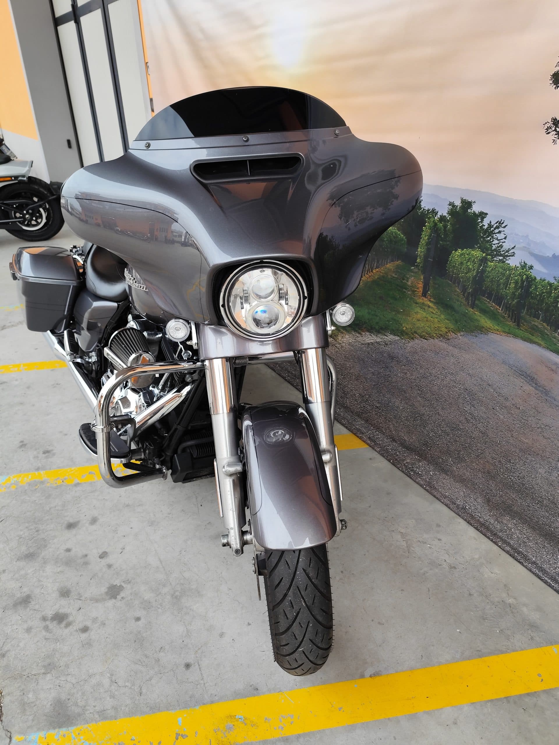 IMG_20260227_085455.jpg Moto Harley-Davidson touring grigia, con carenatura, faro LED e paramotore cromato, esposta in concessionaria. Pronta per test ride.