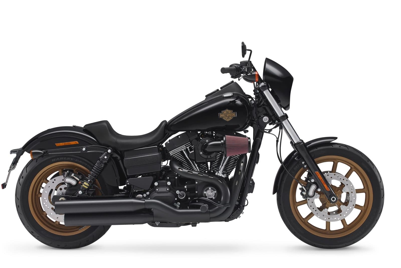 1453974423LowRiderS Harley-Davidson Low Rider S nera con cerchi in bronzo, motore V-Twin, scarico nero e cupolino, su sfondo bianco.