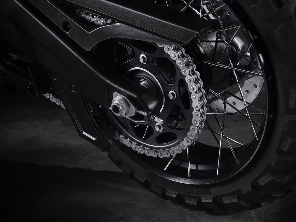 2125_2125_PanA_004.jpg Dettaglio ruota posteriore di una moto Harley-Davidson: catena di trasmissione, corona nera, forcellone e pneumatico tassellato Michelin.