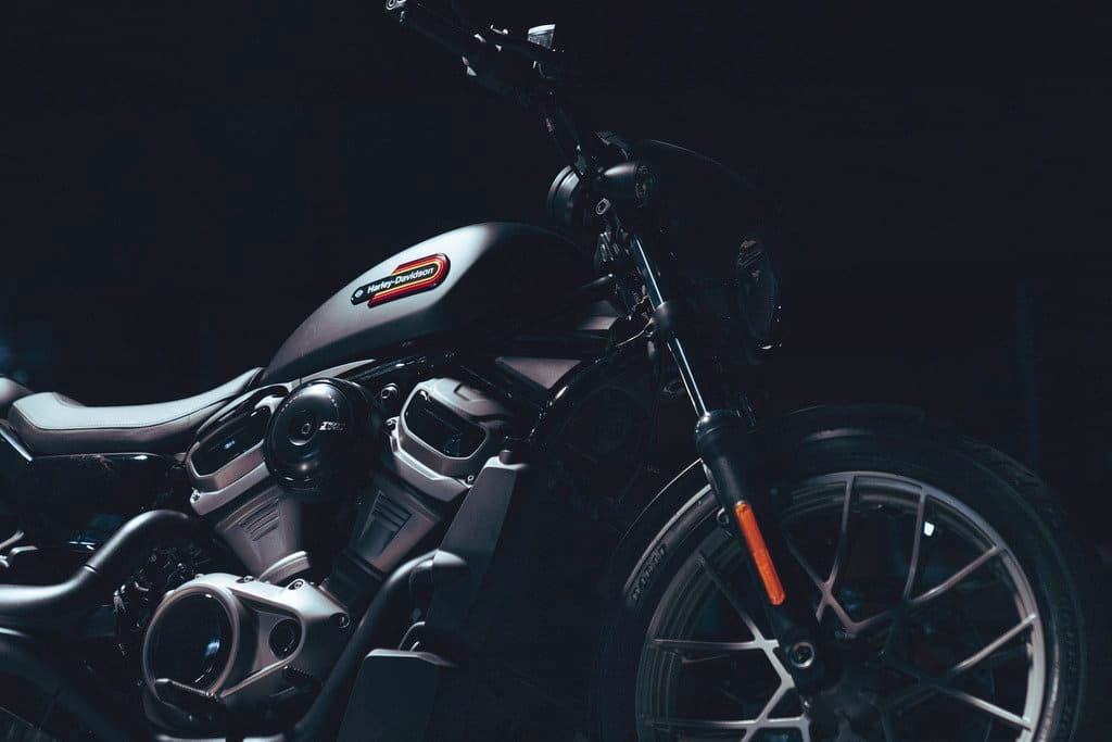23-rh975-nightster-special-detail-bc-0030.jpg Dettaglio ravvicinato di una moto Harley-Davidson moderna, con il logo sul serbatoio, il motore Revolution Max e la ruota anteriore in evidenza.