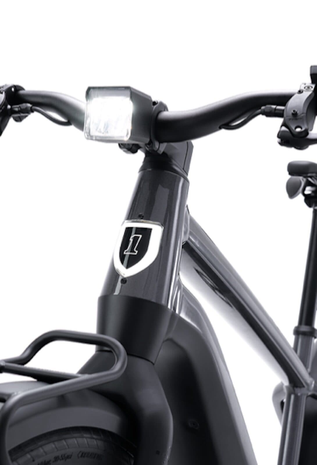4.jpeg Dettaglio della parte anteriore di una bici elettrica Serial 1, brand di Harley-Davidson, con faro integrato, manubrio e logo '1'.