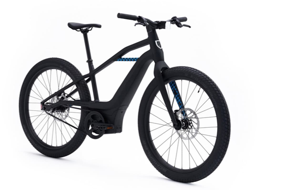 9.jpeg E-bike Serial 1 Harley-Davidson nera opaca con dettagli blu a scacchi, freni a disco e trasmissione a cinghia, su sfondo bianco.