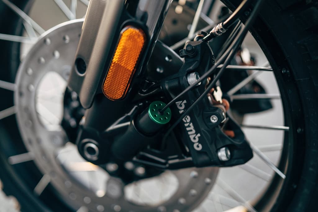 A42_PA.jpg Primo piano della ruota anteriore di una moto Harley-Davidson, con disco freno, pinza Brembo, forcella e regolatore verde.