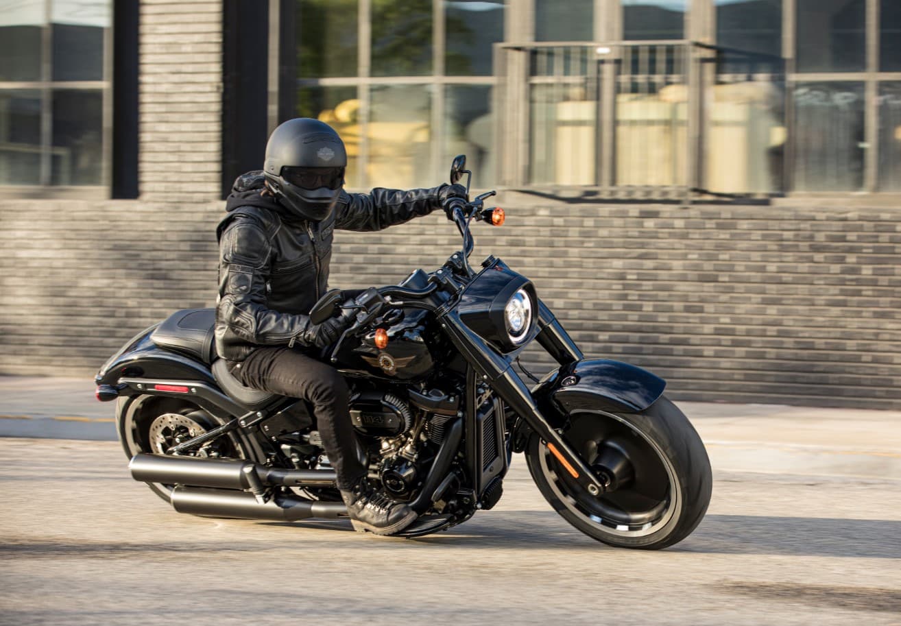 FATBOY3.jpg Motociclista in sella a una Harley-Davidson nera, con abbigliamento tecnico completo, durante un test ride dinamico.