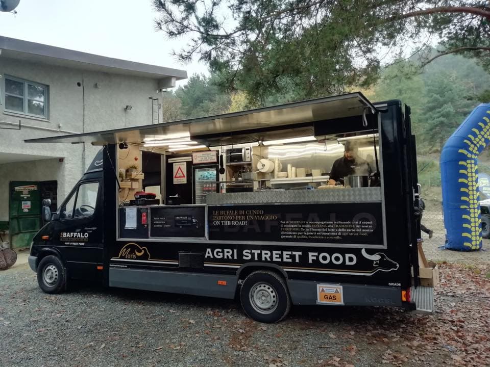 FB_OPENDAY3.jpg Food truck nero Baffalo Agri Street Food con chef a bordo, slogan 'ON THE ROAD!', presente a un evento o raduno per appassionati di motori.