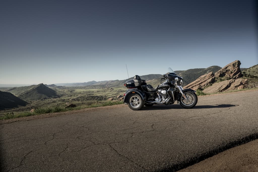 Model Year 2019 GAP Photography. INTERNATIONAL ONLY Harley-Davidson moto a tre ruote nera su strada asfaltata panoramica. Paesaggio montano roccioso e valle verde. Ideale per test ride.