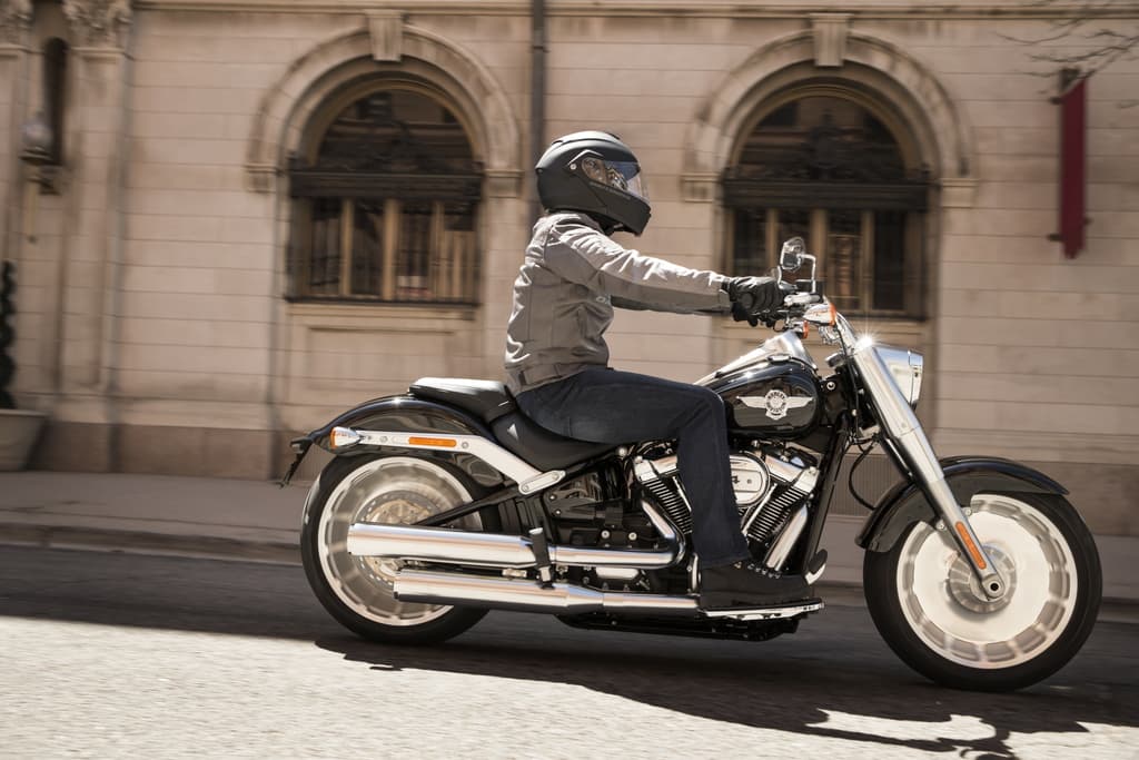 Model Year 2019 GAP Photography. INTERNATIONAL ONLY Pilota con casco e abbigliamento da moto su Harley-Davidson nera in movimento. Perfetta per un test ride e per gli appassionati di motori.