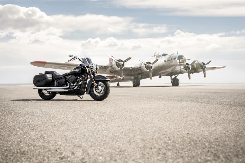 High-Res-JPG-207179_KN_19GAP_181261_FN-2.jpg Harley-Davidson nera, moto touring con parabrezza e borse, su pista aeroportuale con bombardiere B-17 Flying Fortress sullo sfondo.