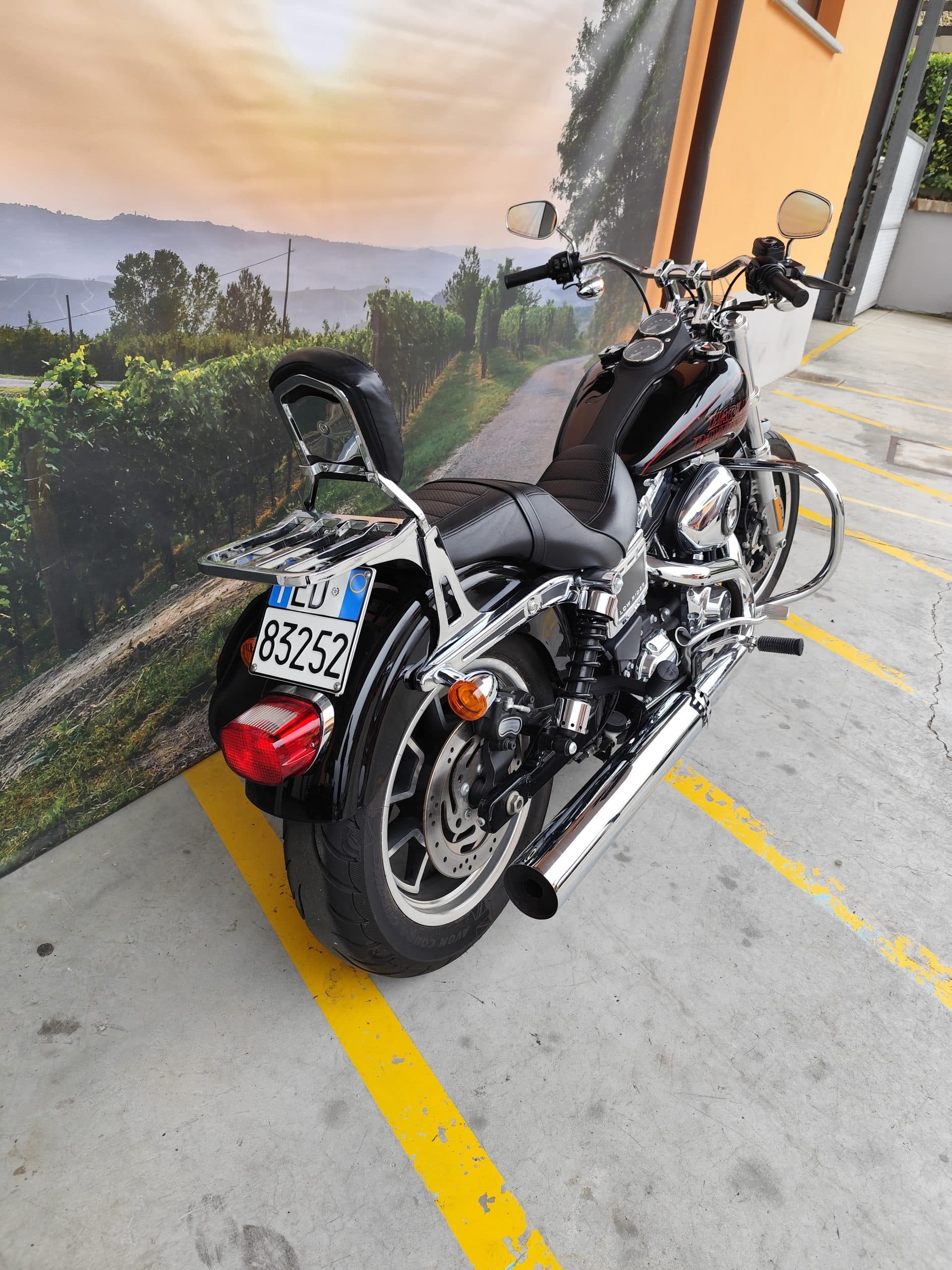 IMG_20260310_151610.jpg Harley-Davidson Low Rider nera, con finiture cromate e sella biposto, esposta su sfondo paesaggistico di vigneti. Perfetta per un test ride.