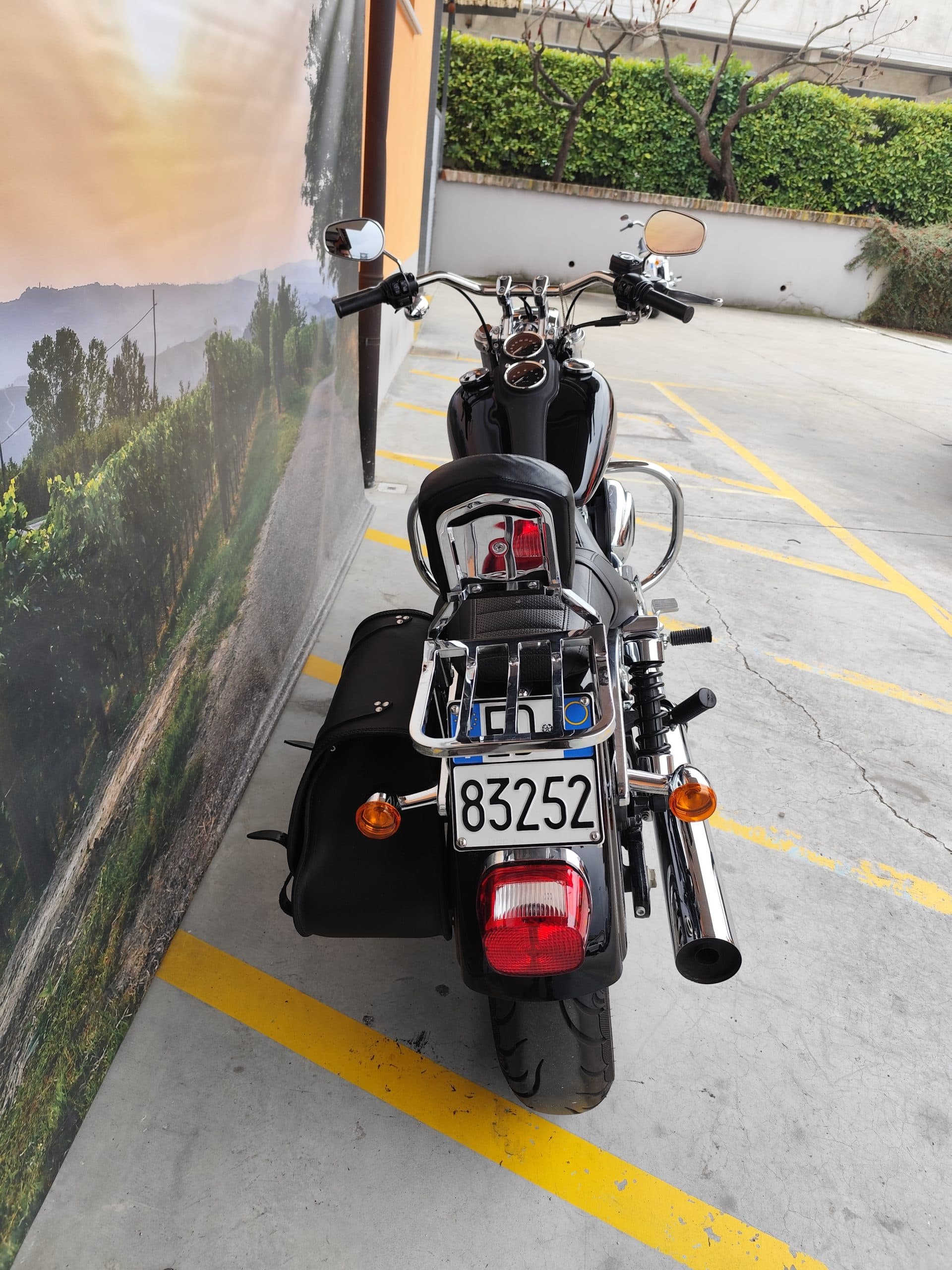 IMG_20260310_151613.jpg Harley-Davidson nera parcheggiata, vista posteriore. Dettagli cromati, borsa laterale e targa 83252. Ideale per test ride.