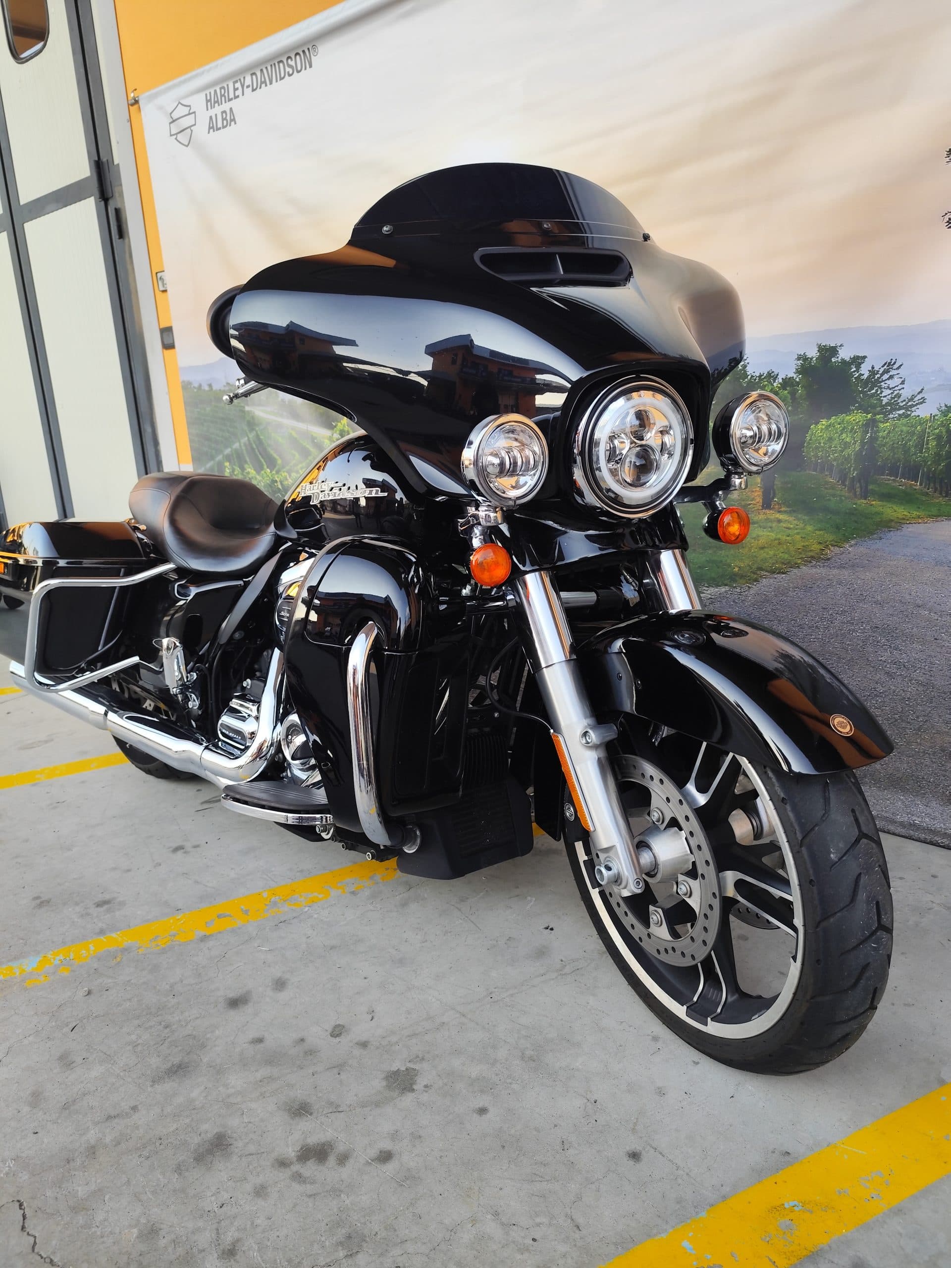 IMG_20260312_165750.jpg Harley-Davidson touring nera, modello Street Glide o Electra Glide, esposta presso la concessionaria di Alba. Dettagli cromati, fari LED e logo visibile.