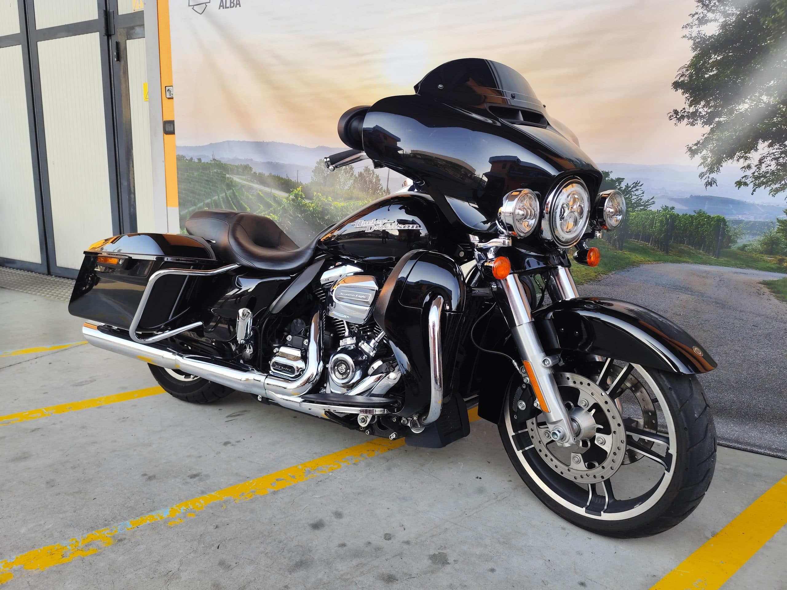 IMG_20260312_165753.jpg Moto Harley-Davidson touring nera lucida, con motore Screamin' Eagle, esposta su sfondo paesaggistico delle Langhe. Ideale per test ride.