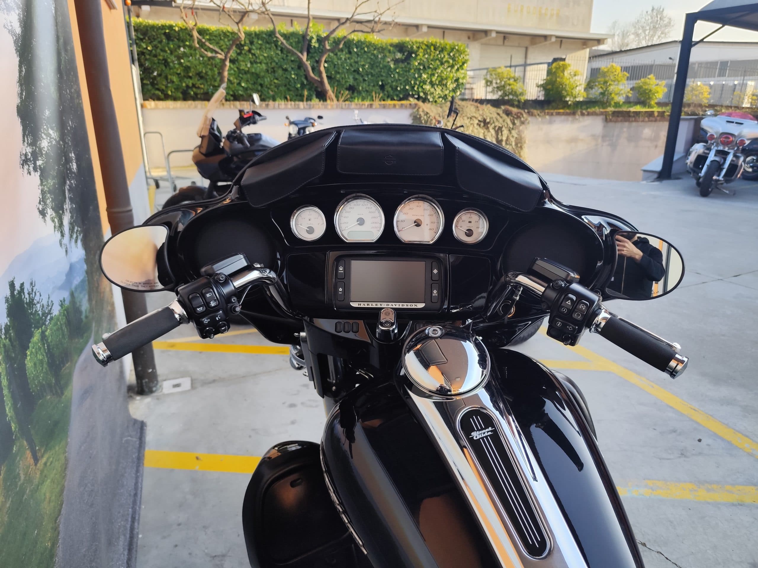 IMG_20260312_165910.jpg Cruscotto e parte anteriore di una Harley-Davidson Street Glide nera lucida, con manubrio, strumentazione analogica e display digitale. Visibile il logo Street Glide sul serbatoio.
