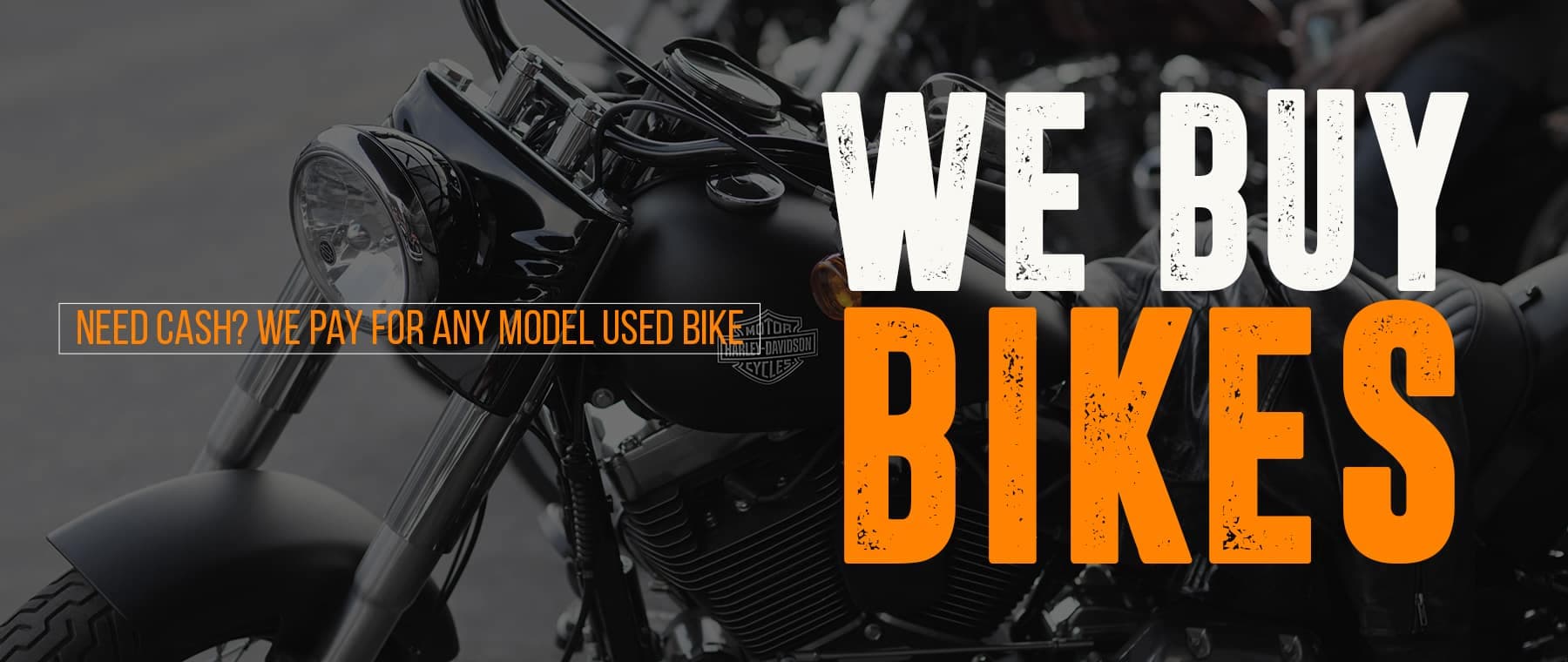 webuybikesbigbanner Banner pubblicitario con una moto Harley-Davidson nera in primo piano e il testo "WE BUY BIKES" in bianco e arancione. Sotto, una riga di testo arancione recita "NEED CASH? WE PAY FOR ANY MODEL USED BIKE".