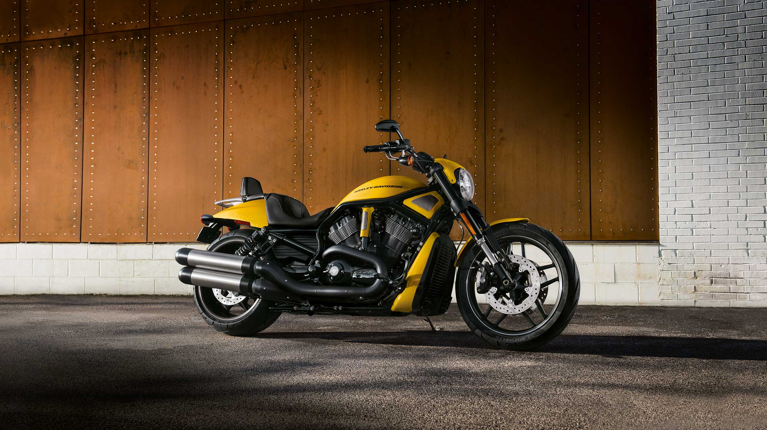 Harley-Davidson V-Rod gialla: potenza e design unico Harley-Davidson V-Rod gialla, motore V-twin nero, scarichi cromati, parcheggiata su asfalto. Ideale per test ride.